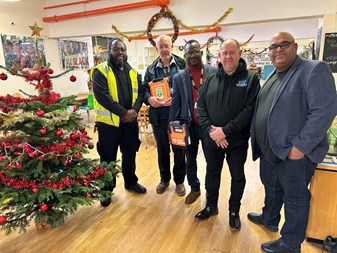 Staff with the defibrillator in the community centre